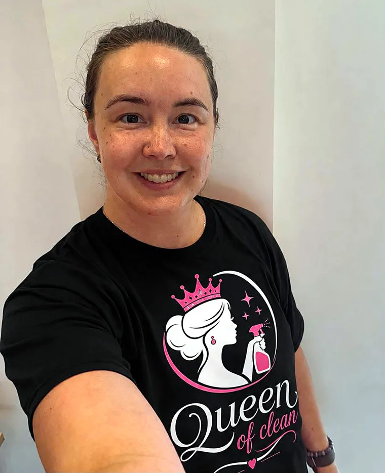 Lucy Cranfield, founder of The Queen of Clean, smiling in her branded t-shirt