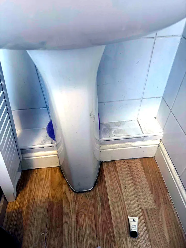 Dusty, marked skirting boards and basin pedestal before cleaning