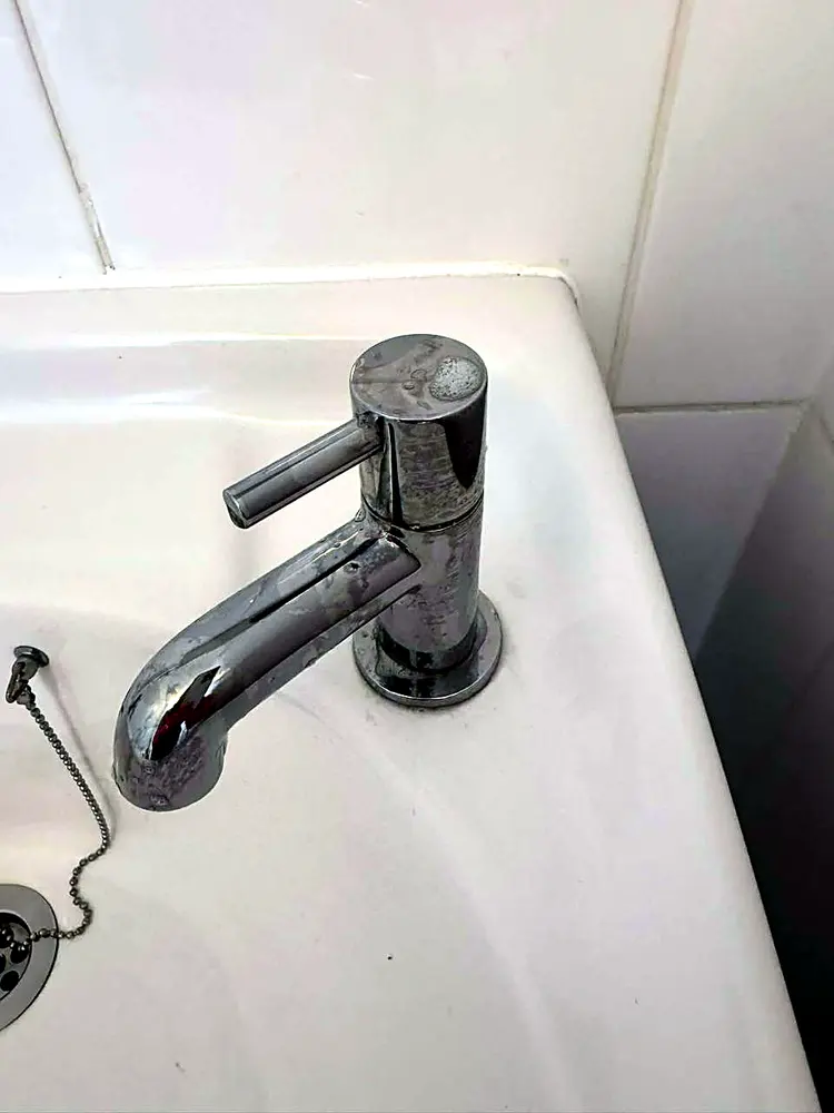 Bathroom tap dulled with water spots and limescale, before cleaning